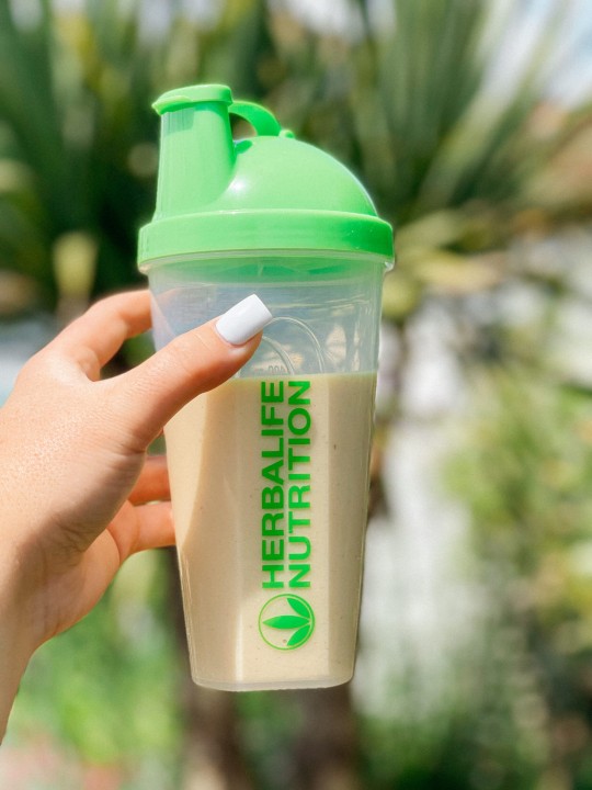 Herbalife Nutrition Shake in Hand with Green Shaker Bottle.jpeg