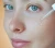 li-woman-applying-facial-serum-dropper-skincare-routine.webp